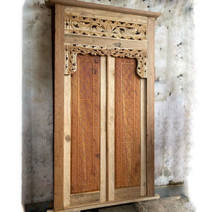 Hand-carved Balinese wooden door with intricate ethnic patterns and ornate detailing