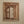 Hand-carved Balinese wooden window frame with intricate floral detailing on a beige wall.