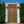 Balinese hand-carved wooden door with intricate patterns in a white outdoor frame