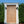 Hand-carved vintage Balinese wooden door with ornate details set in a white frame outdoors