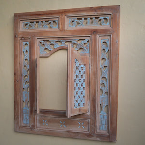 Hand-carved wooden window frame with intricate Balinese floral patterns and rustic finish
