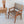 Handwoven rattan chair with geometric pattern beside carved wood table and rattan lamp