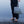 Handwoven seagrass beach bag held by woman on wet sand, eco-friendly coastal accessory