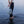 Handwoven seagrass beach bag held by woman standing in ocean waves, eco-friendly coastal accessory
