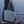 Handwoven seashell tote bag carried by woman walking on beach, eco-friendly beach accessory