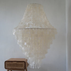 Large handmade seashell chandelier with white capiz shells in a minimalist room