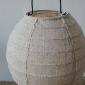 Close-up of a handmade linen table lamp with a natural textured fabric shade