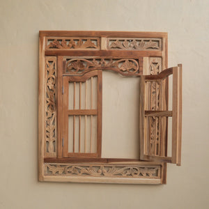 Hand-carved Balinese wooden frame with floral patterns and open side panel on beige wall