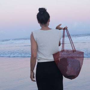 copper mesh tote bag with patterned handles.