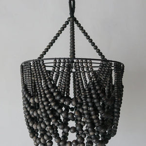 Boho black wooden bead chandelier with handcrafted Balinese design on white background