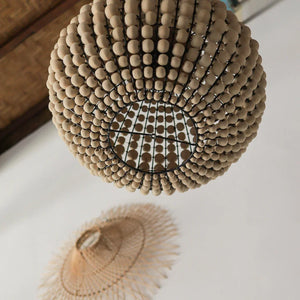 Handcrafted wooden bead chandelier and woven bamboo ceiling lamp in modern interior