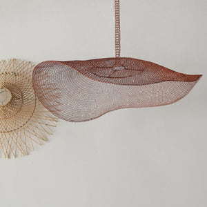 Handmade wire mesh pendant light with wavy design and rattan wall art on white background