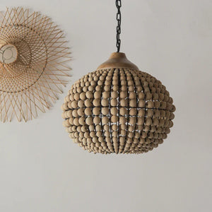 Handmade wooden beaded chandelier pendant light with a rattan wall decor on a white wall
