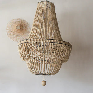 Handmade Balinese beaded chandelier with natural wood elements on a light wall