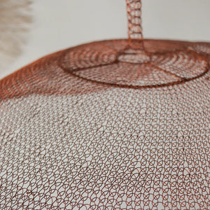 Copper wire mesh pendant lamp with intricate woven pattern on a white background