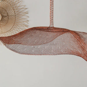 Handcrafted copper wire mesh pendant light with modern geometric design against white wall