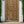 Vintage hand-carved wooden door with geometric patterns set in a white frame outdoors.