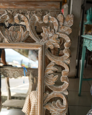 Hand-carved wooden mirror with intricate Balinese floral design and rustic finish
