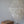 Handmade seashell chandelier and carved wooden side table in minimalist room