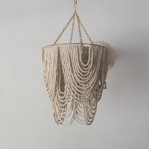 Beaded chandelier in gold and white wash, handcrafted from Bali, perfect for home decor.