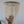 Hand touching a white beaded seashell chandelier with cascading strands, boho home decor