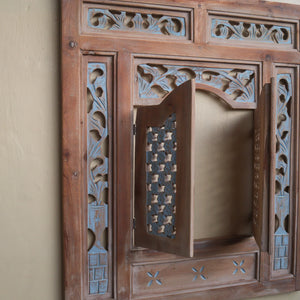 Hand-carved wooden window frame with intricate floral and geometric patterns