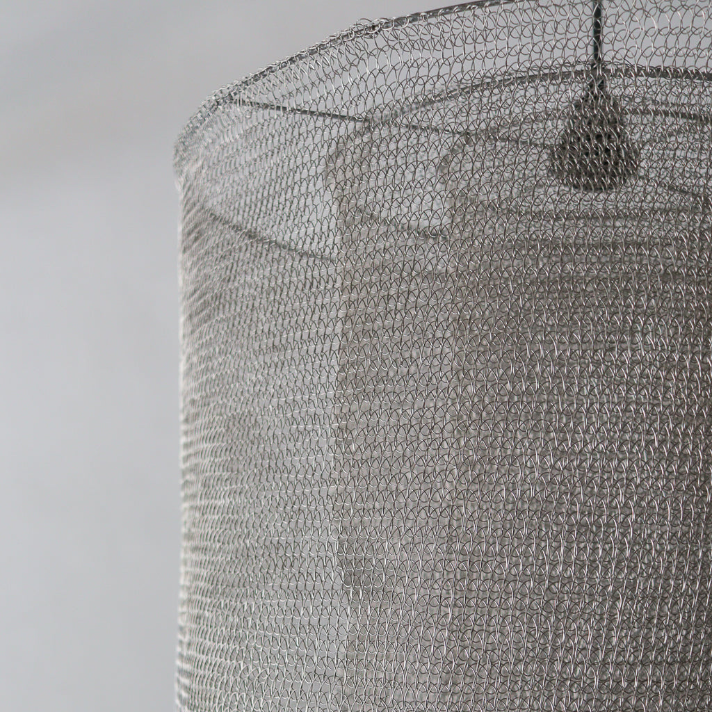 Close-up of a textured gray lampshade on a plain background