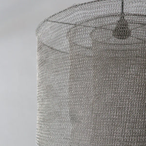 Close-up of a textured gray lampshade on a plain background