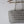A silver metallic woven mesh tote bag hanging from a wooden rod against a plain white wall.