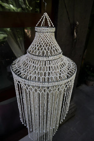 Handcrafted Balinese seashell chandelier with cascading beaded strands in natural light