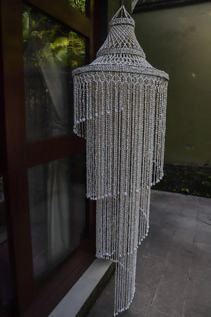 Handmade Balinese seashell chandelier with cascading bead strands outdoors