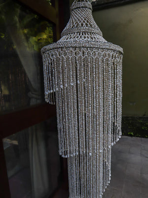 Handmade Balinese seashell chandelier with cascading shell strands, outdoor setting