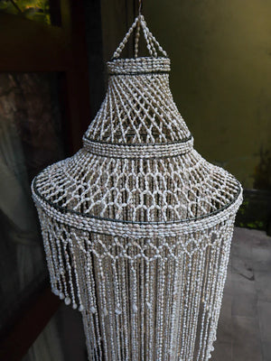 Handmade Balinese seashell chandelier with intricate beaded design, hanging outdoors