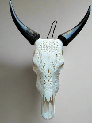 Hand-carved decorative cow skull with ornate floral patterns and dark horns for wall decor