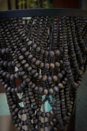 Handmade beaded chandelier with dark wood beads and a black circular frame