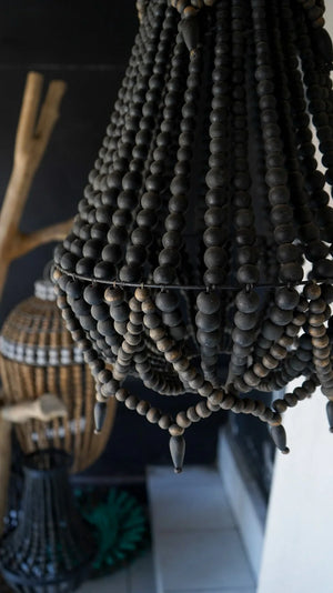 Handmade black beaded chandelier with natural wood accents in a modern interior setting