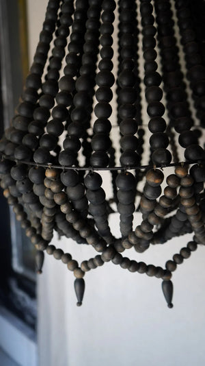 Close-up of a handmade black wooden bead chandelier, boho home decor lighting