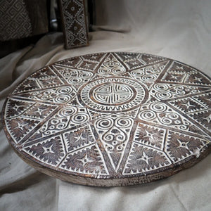 Round hand-carved wooden tray with intricate Balinese geometric and spiral patterns
