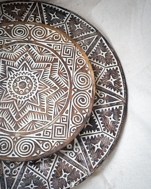 Hand-carved Balinese wooden plates with intricate geometric tribal patterns