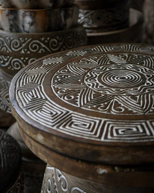 Hand-carved wooden stool with intricate Balinese geometric and swirl patterns