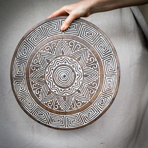 Hand-carved round wooden wall art with intricate Balinese geometric patterns