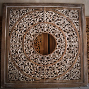 Hand-carved Balinese wood wall panel with intricate floral and circular patterns.