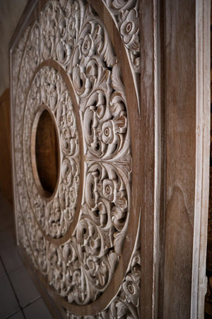 Hand-carved Balinese wood panel with intricate floral and circular patterns