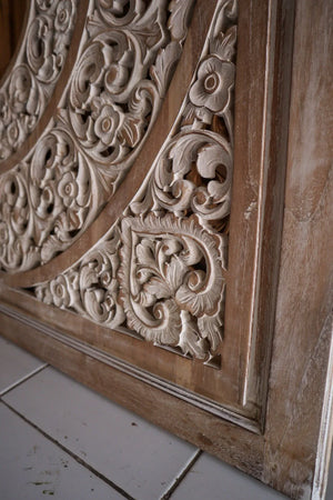 Hand-carved Balinese wooden door panel with intricate floral patterns