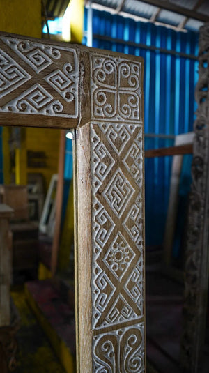 Hand-carved wooden door frame with intricate Balinese geometric patterns