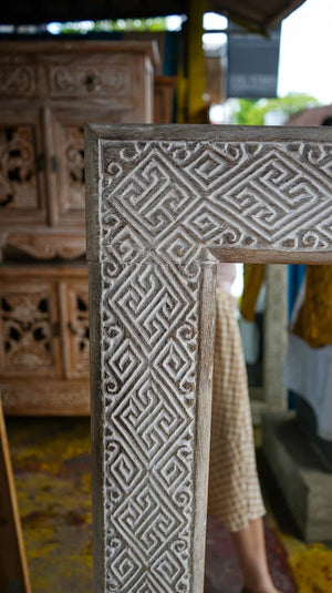 Hand-carved wooden door frame with intricate Balinese geometric patterns