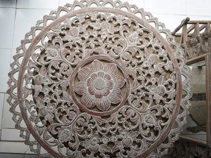 Round hand-carved wood wall art with intricate floral Bali-inspired pattern