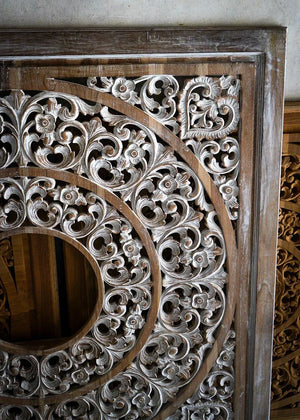 Hand-carved Balinese wood wall panel with intricate floral patterns and circular design