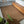 Handwoven Balinese rattan rug in a modern bedroom with wood platform bed and indoor plant