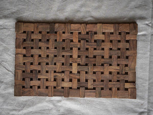 Handwoven wooden placemat with geometric pattern on linen fabric